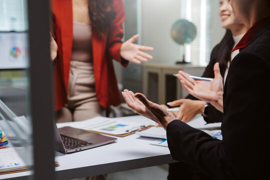 Business team collaborating on a project, analyzing data in a professional office boardroom during a lively discussion
