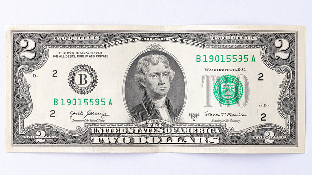 A detailed close-up image of multiple two-dollar bills featuring the portrait of Thomas Jefferson, arranged in an overlapping manner. Two american dollars banknote close up.