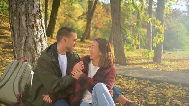 Romantic young multiracial couple enjoying a date in an autumn park.