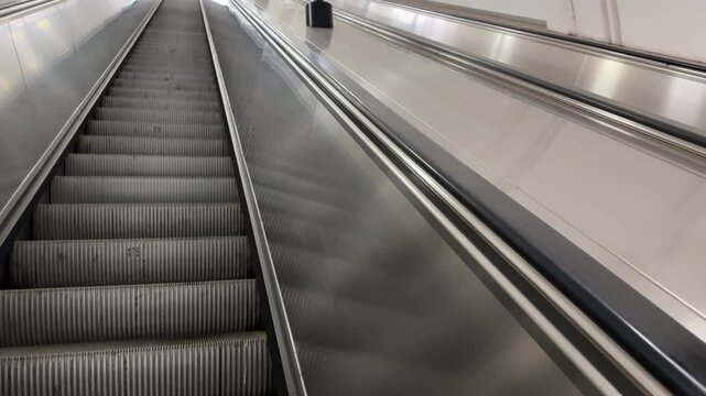 Rubber escalator handrail moves upward slightly faster than steps. Escalators are characterized by different speed of stairs and handrail. Be careful and safe on moving escalator