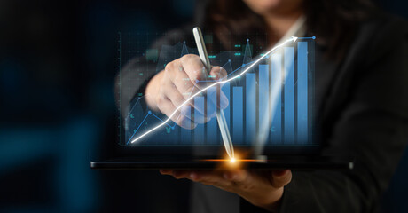 A business professional actively using a digital tablet to analyze financial data, showcasing graphs and charts in a modern and innovative office environment. Impute