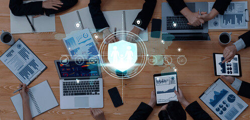 A top-down view of a business meeting showcasing professionals analyzing data and reports, emphasizing teamwork and the role of technology in decision-making. Trope