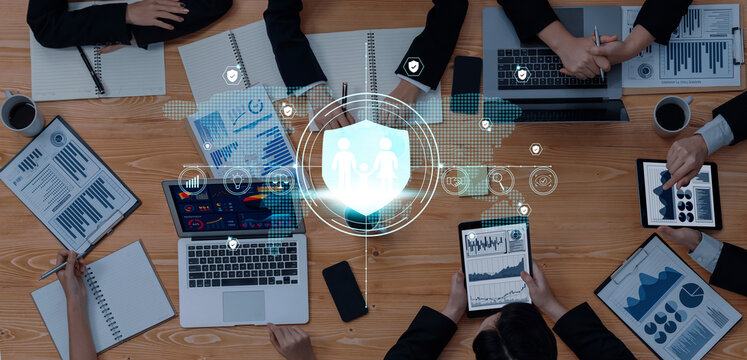 A top-down view of a business meeting showcasing professionals analyzing data and reports, emphasizing teamwork and the role of technology in decision-making. Trope