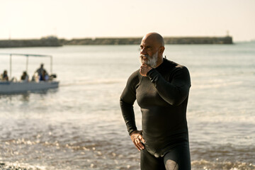 Mature man enjoying paddle surfing activity on beach