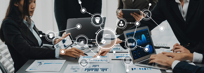 A dynamic scene of a modern business meeting featuring professionals engaged in discussions while utilizing various digital devices for effective communication and data analysis. Amity