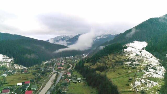 Mountain village in slope valley, view from drone