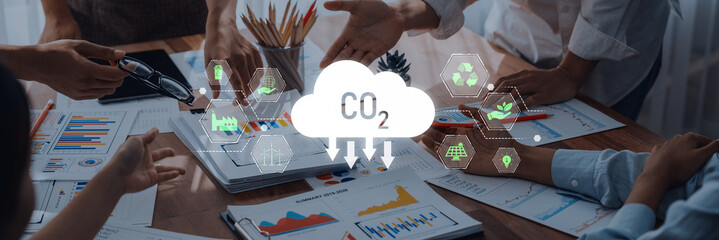 A business team engages in a discussion about sustainable strategies, analyzing charts and graphs while highlighting the importance of reducing CO2 emissions. Trope