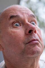 Astonished senior man, male face with silly expression and funny mimic, strong facial surprise and...
