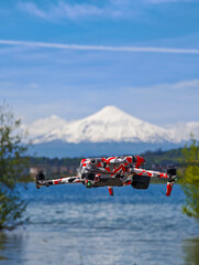 Close-up of a drone flying with a volcano in the background.
