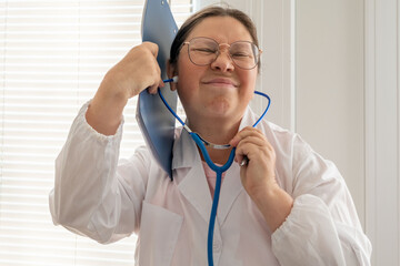 funny playful female woman doctor or nurse in white lab coat with stethoscope and blue clipboard, friendly female physician, prepared examination or checkup, stress relief, emotional intelligence
