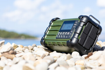 Rugged Handheld Radio With Digital Display On Pebble Ground For Fieldwork