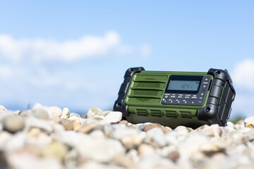Rugged Handheld Radio With Digital Display On Pebble Ground For Fieldwork