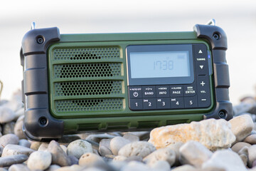 Rugged Handheld Radio With Digital Display On Pebble Ground For Fieldwork