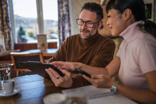 Business colleagues collaborating on digital tablet in cafe