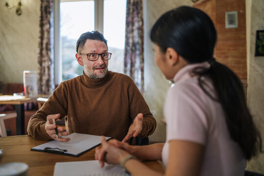 Man counseling young woman during business meeting