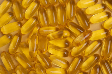 Pile of golden fish oil capsules for health and nutrition. Essential Omega-3