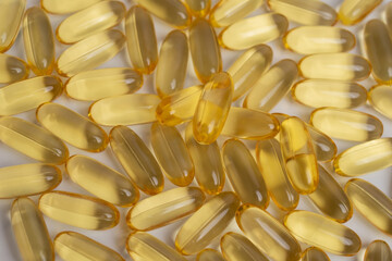Pile of golden fish oil capsules for health and nutrition. Essential Omega-3.
