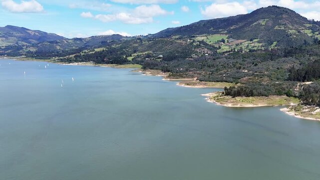 Plano general de la Laguna de Tomin&eacute; en Cundinamarca - Colombia, donde se muestra las monta&ntilde;as y paisajes naturales que rodean la laguna y los veleros que navegan en ella.