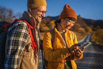 Hiking couple navigating outdoors using smart phone app