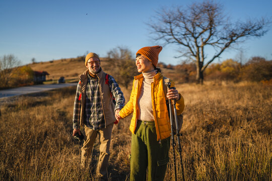 Couple hiking holding hands enjoying autumn nature journey