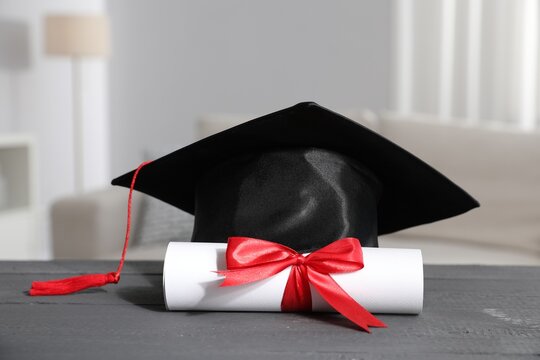 Diploma and graduation hat on grey wooden table indoors, closeup - Powered by Adobe