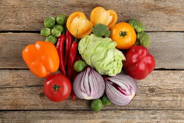 Different fresh raw vegetables on wooden table, flat lay