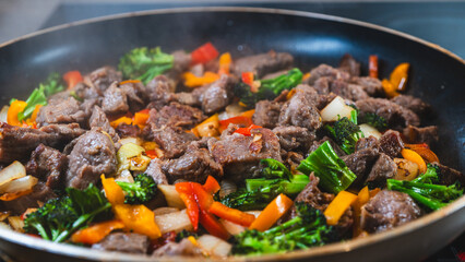 Beef strips sizzling with broccoli, bell peppers, and onions in a dry fry. Golden brown, juicy, and perfectly cooked for a healthy meal.