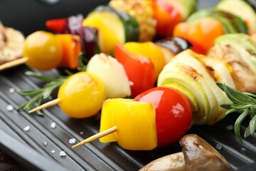 Skewers with tasty vegetables on grill pan, closeup