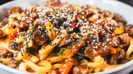 Smoking hot beef udon with broccoli, onions, and bell peppers in a beautiful bowl. Rich broth,...