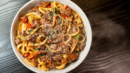 Smoking hot beef udon with broccoli, onions, and bell peppers in a beautiful bowl. Rich broth, fresh vegetables, perfect for Japanese cuisine lovers.