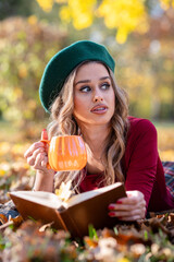 A beautiful woman reading a book in an autumn park