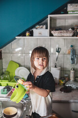 A little girl washing dishes