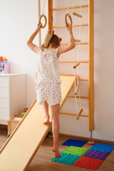 Obraz premium Child climbing wooden indoor play structure