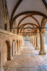 A long hallway with arched ceilings and red brick walls in Lubeck Germany. The arches are decorated with white trim