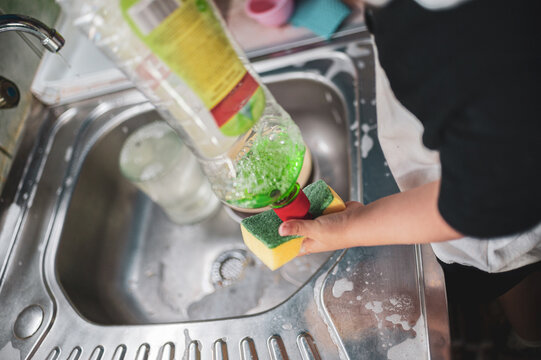 A little girl washing dishes