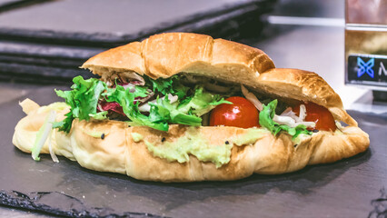 Croissant sandwich with chicken, lettuce and tomato