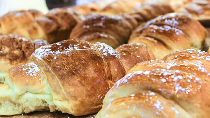 Freshly baked sweet breakfast pastry croissant roll on a brown wooden table