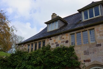Stone house facade in a travel category image upload. The house has a dormer window, and some greenery is creeping up the wall