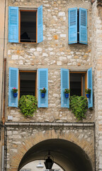 Typical windows with shutters and flowerpots. Historic city of Vence, France