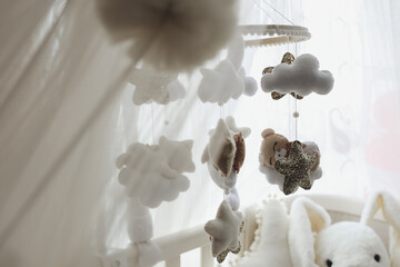 Close up of a felt nursery mobile with clouds, stars and animals,highlighting handmade...