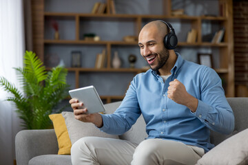Happy man winning and celebrating success using tablet