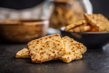 Crunchy salted crackers on black table.