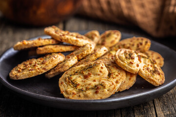 Crunchy salted crackers on plate on wooden table.