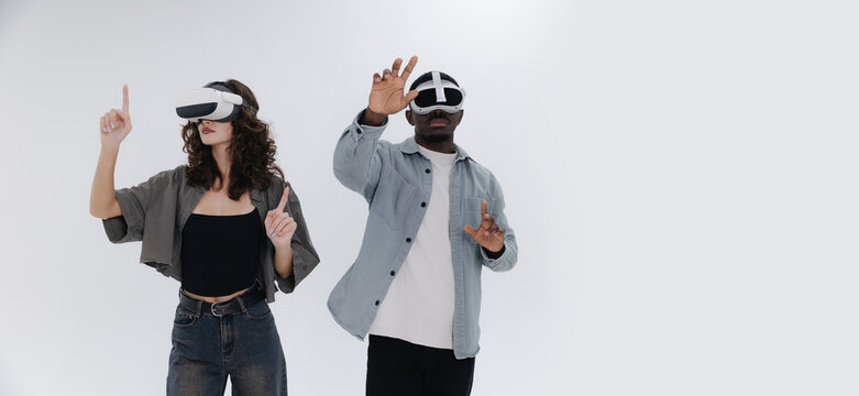 Adults African male and Asian female engaging with virtual reality technology on white studio background, Banner with copy space for text