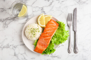 Piece of tasty grilled salmon with rice served on light marble table, flat lay