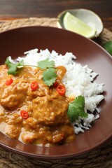 Chicken tikka masala with rice served on wooden table, closeup