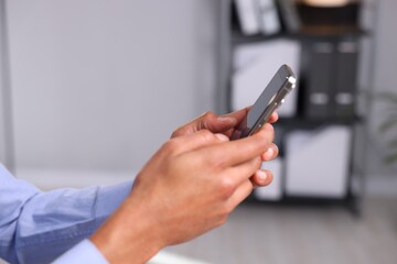 African-american man using smartphone in office, closeup