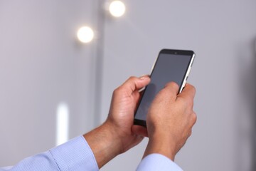 African-american man using smartphone in office, closeup