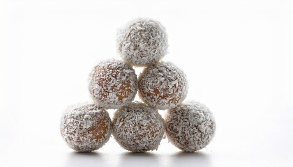 a pyramid stack of healthy raw energy balls covered in desiccated coconut isolated on a white background