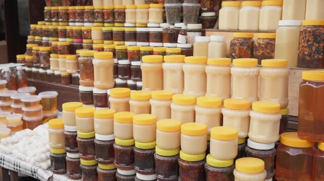 Varieties of honey in jars on display at local eco market. Natural products, organic food production. Superfoods rich in vitamins and microelements. Small business, apiary, products. Vegan friendly